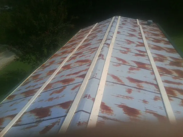 Rusted metal roof panels with new wood purlins before replacement — Storm Damage Roof Repair in Ferguson by Roofing Brothers